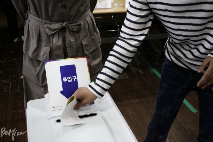 모의투표에서 발달장애인 유권자가 투표용지를 투표함에 넣으려고 했지만 입구가 작아 어려움을 겪고 있다. 