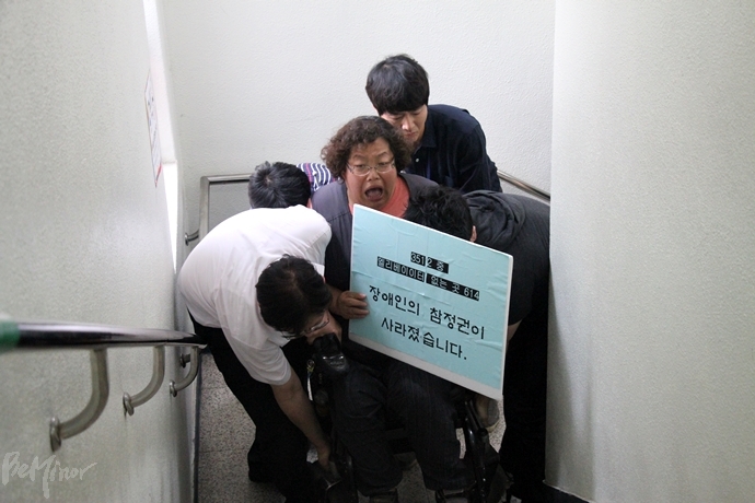 투표소 직원들이 이형숙 노들장애인자립생활센터 소장의 전동휠체어를 들어서 2층으로 옮기려 했으나 역부족이었다.