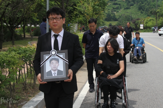 권오진 씨의 마지막 길을 배웅하고 있는 인천장애인차별철폐연대 회원들.