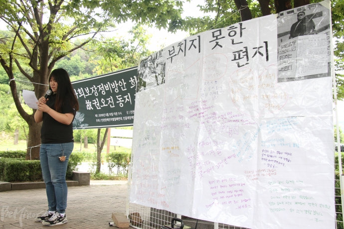한 활동가가 권오진 씨에게 '부치지 못한 편지'를 낭독하고 있다.