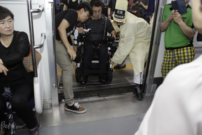지하철과 플랫폼 사이가 넓어 휠체어가 빠질까봐 활동가들이 휠체어를 들어 올려야 했다.