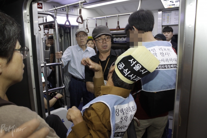 한 시민이 지하철과 승강장 사이에 걸쳐 있는 휠체어 이용자를 밀어내려고 하다가 활동가들에게 제재를 당했다.