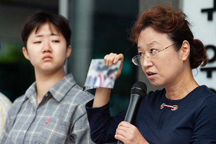 이찬 씨 어머니가 사진에 담긴 즐거운 추억에 관해 얘기하고 있다.