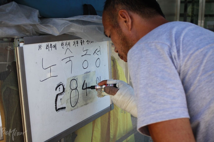 형제복지원 피해생존자 양세환 씨가 농성 일수를 고쳐 쓰고 있다. 