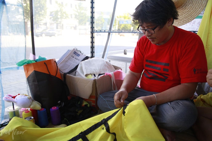 한종선 씨가 농성 300일을 맞아 9월 3일 열리는 문화예술행동을 준비하며 바느질 중이다. 