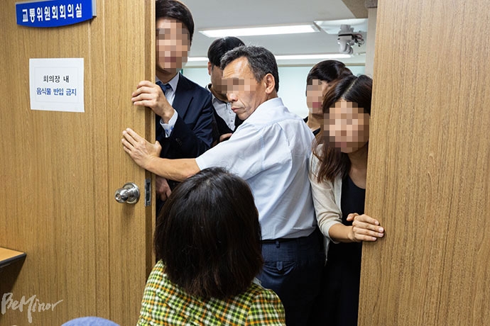 서울시 직원들이 교통위원회 회의실 입구를 막고 있다.