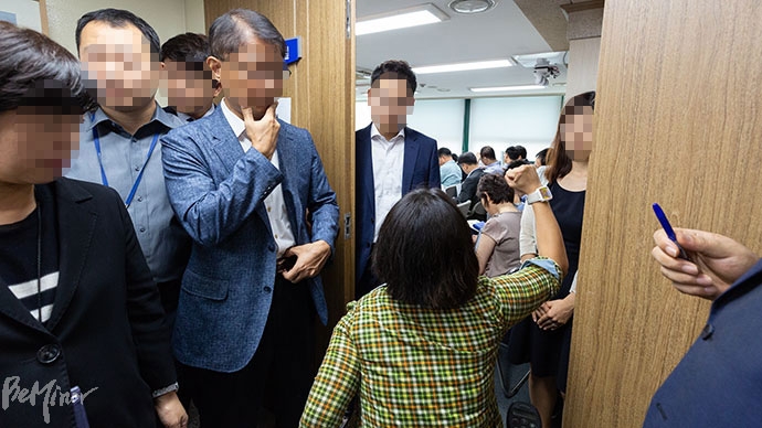 문애린 서울장차연 활동가(가운데 팔 들고 있는 사람)가 회의장 안을 향해 고홍석 본부장을 부르고 있다.