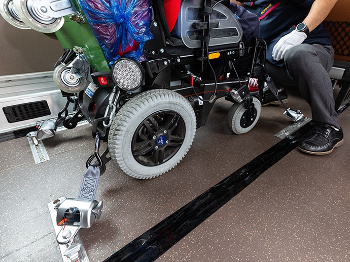 휠체어를 고정하기 위한 벨트가 휠체어에 걸려있다. 휠체어를 고정하기 위한 벨트가 휠체어에 걸려있다.