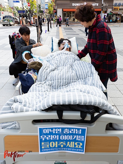 호흡기를 단 채 침대에 누워있는 임성엽 씨. 그의 오른쪽에 어머니가 서있다.