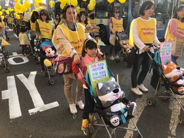 '국공립 어린이집'의 공공성 확대를 촉구하는 행진 참여자들이 유모차를 밀며 행진하고 있다. 