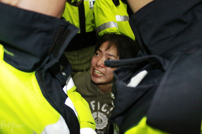 한 장애인 활동가가 경찰에 의해 둘러싸이자 항의하고 있다. 장애인 활동가들이 박원순 시장 면담을 촉구하며 서울시청 앞에서 무기한 농성을 선포하자, 이를 막아서려는 경찰과 장애인 활동가들이 대치하고 있다.