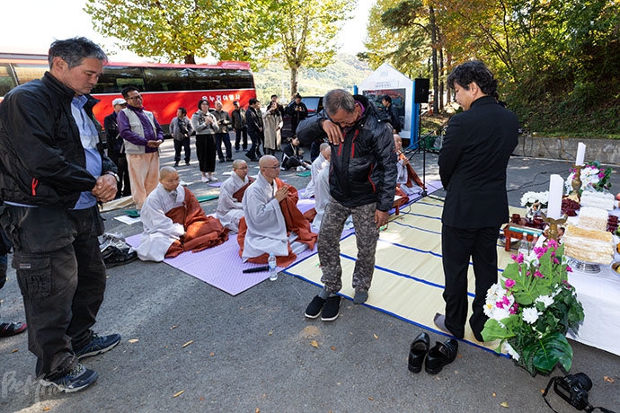 위령제에 참여한 동자동 거주자 한 사람이 무연고 사망자들에게 헌주한 후 울음을 터뜨리고 있다