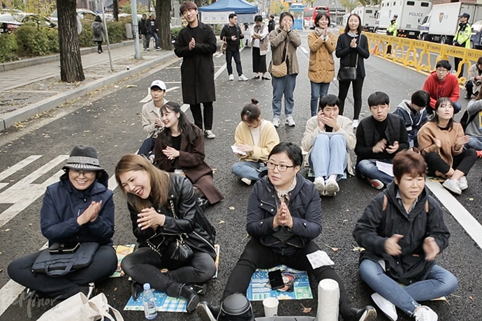 용기있게 차별 경험을 증언한 무대 위 발언자를 향해 응원을 보내는 사람들. 