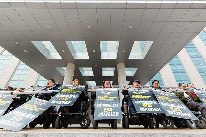 사다리와 쇠사슬을 목에 걸고선 내년도 장애인 복지 예산 확대를 촉구하는 장애인 활동가들. 