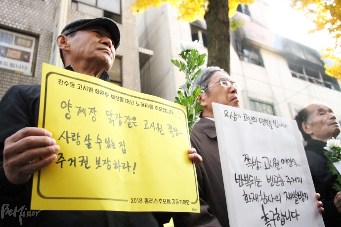 한 기자회견 참가자가 '양계장 닭장같은 고시원, 쪽방...사람 살 수 있는 집, 주거권 보장하라!'는 문구가 적힌 손피켓을 들고 있다.