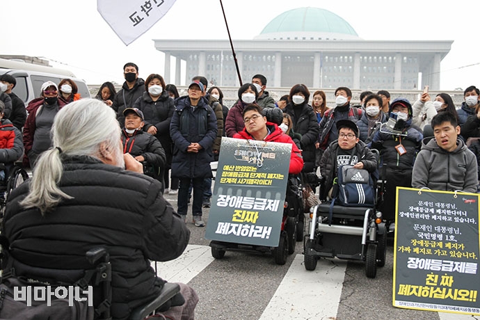 장애인 당사자들이 국회 앞 8차선 도로를 사다리와 쇠사슬로 자신의 몸을 결박한 채 점거하며 내년도 장애인복지 예산 확대를 촉구했다. 강혜민 기자. 장애인 당사자들이 국회 앞 8차선 도로를 사다리와 쇠사슬로 자신의 몸을 결박한 채 점거하며 내년도 장애인복지 예산 확대를 촉구했다. 강혜민 기자.