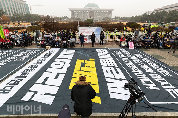국회 앞에 ‘장애등급제 진짜 폐지하라’라고 적힌 대형 현수막이 펼쳐졌다. 박승원 기자. 국회 앞에 ‘장애등급제 진짜 폐지하라’라고 적힌 대형 현수막이 펼쳐졌다. 박승원 기자.