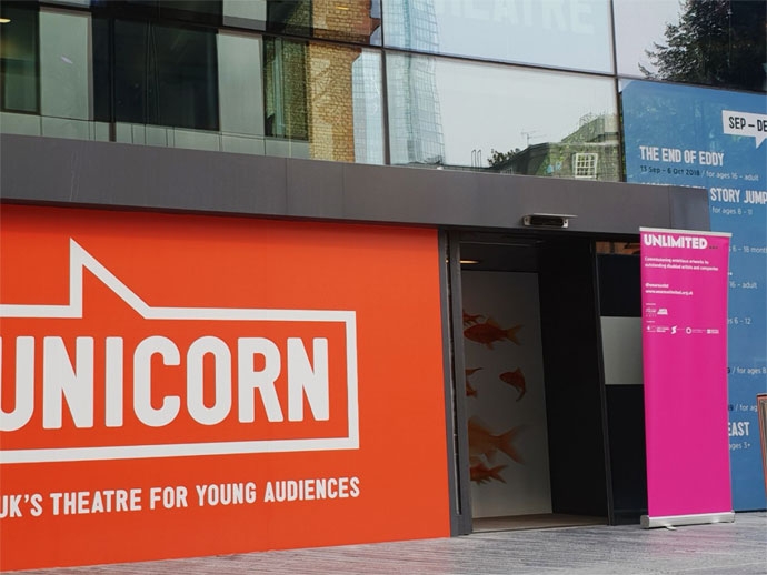 런던에 위치한 유니콘 극장. 로고가 쓰인 정문 사진이다. 언리미티드 페스티벌을 소개하는 입간판이 화면 오른쪽에 서 있다