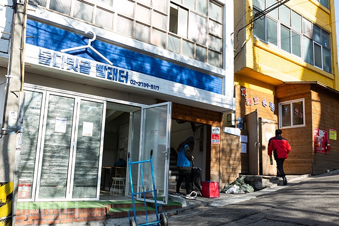 파란색 페인트로 칠한 '돌다릿골 빨래터'와 노란색 페인트로 칠한 '해 뜨는 집' 건물이 나란히 있다.