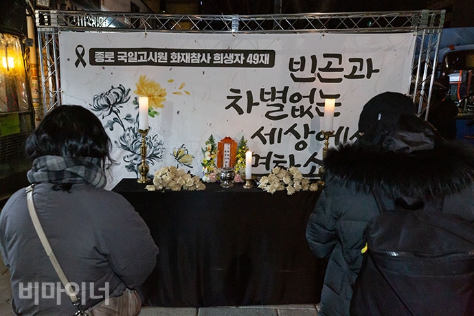 국일고시원 화재 희생자 추모문화제에 모인 참가자들이 영정 앞에서 헌화하는 모습.