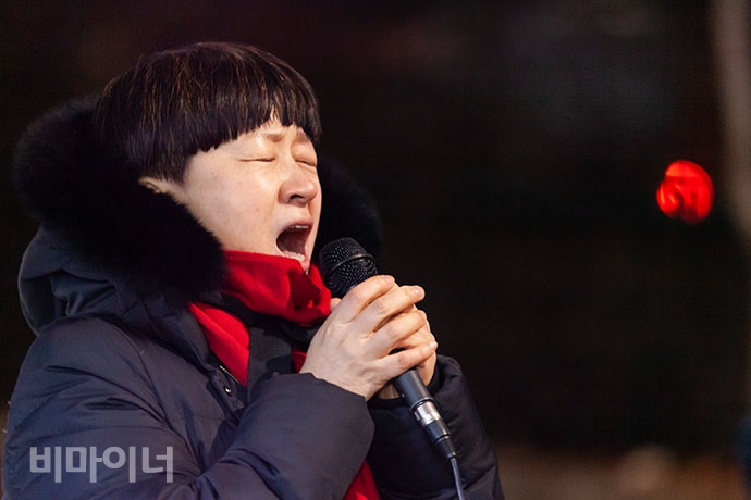 류금신 노동가수가 국일고시원 앞에서 죽은 이의 넋을 기리며 노래하고 있다.
