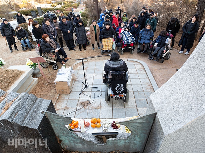 우동민 열사 추모제에 참가한 사람들이 발언자가 하는 말에 귀 기울여 듣고 있다.