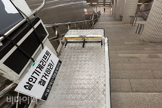 지난해 1월 장애인이 사망한 신길역 휠체어리프트. 신길역 환승구간엔 엘리베이터가 없어 휠체어 이용 장애인은 리프트를 이용해야만 한다. 리프트 위에 ‘살인기계 리프트 철거하라’는 팻말이 놓여 있다.