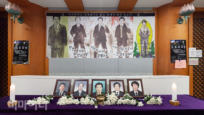 용산참사 당시 목숨을 잃은 다섯 사람의 영정 앞으로 국화꽃이 놓여있다.