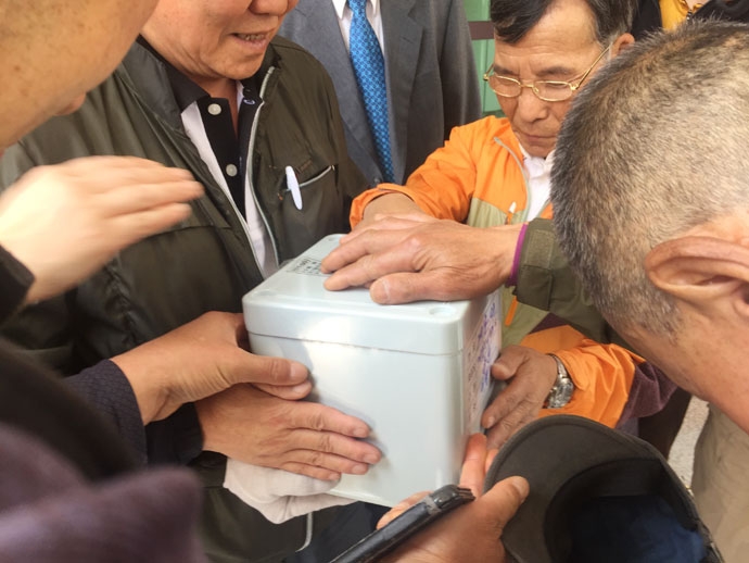 서울역 동자동 쪽방 주민들이 무연고사망자 장례에 참여해 함께 살던 쪽방 주민의 유골함에 손을 얻으며 마지막 인사를 하고 있다. ⓒ나눔과나눔