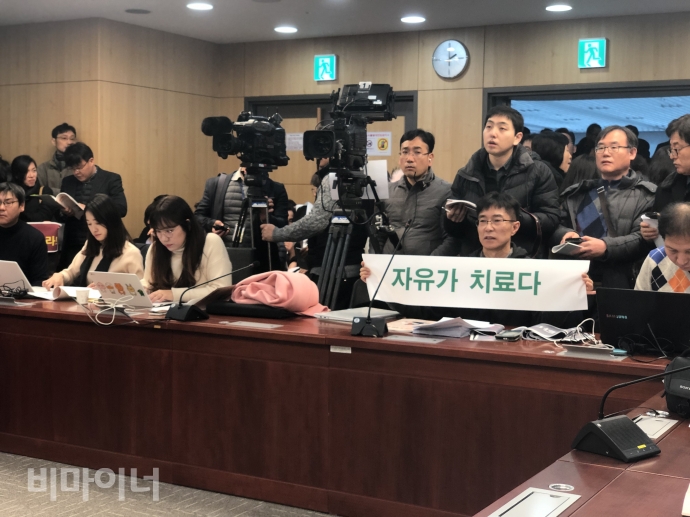 정신건강복지법 개악안에 반발하며 공청회에서 공대위 소속 활동가가 ‘자유가 치료다’라고 적힌 현수막을 들고 있다. 