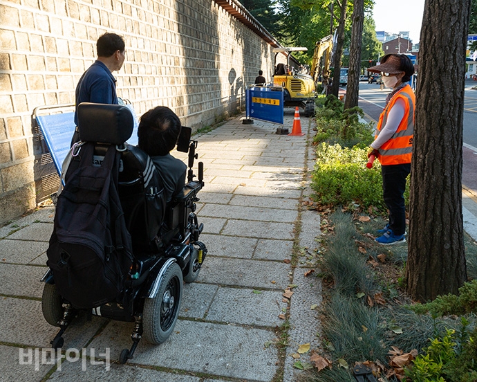 인도 위에 전동휠체어를 탄 사람이 있다. 그러나 그의 앞 인도가 공사 중으로 막혀 있다. 사진 박승원. 인도 위에 전동휠체어를 탄 사람이 있다. 그러나 그의 앞 인도가 공사 중으로 막혀 있다. 사진 박승원.