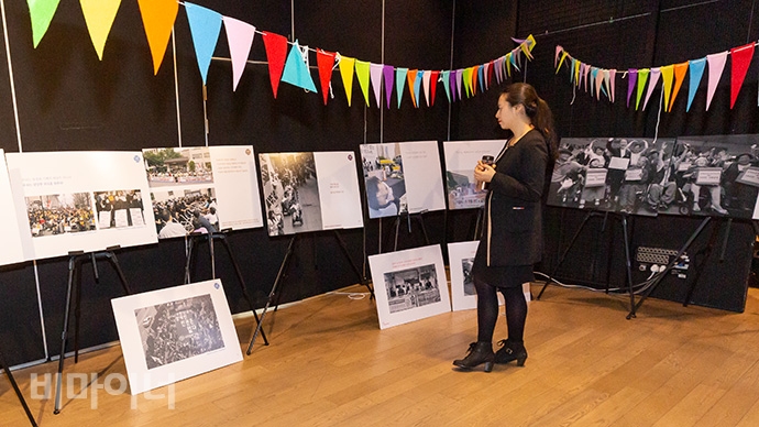 전국장애인차별철폐연대가 19일 오후 2시 서울시청 시민청 바스락홀에서 ‘전장연 10년 사진집 출간기념회’를 열었다. 한 참석자가 전시한 사진을 감상하고 있다.
