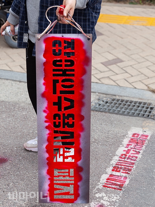 장애인활동가들이 기획재정부 건물 앞 도로에 ‘장애등급제 폐지’, ‘장애인수용시설 폐지’, ‘부양의무제 완전 폐지하라’ 등의 문구를 스프레이 라카로 새기고 있다. 사진 박승원