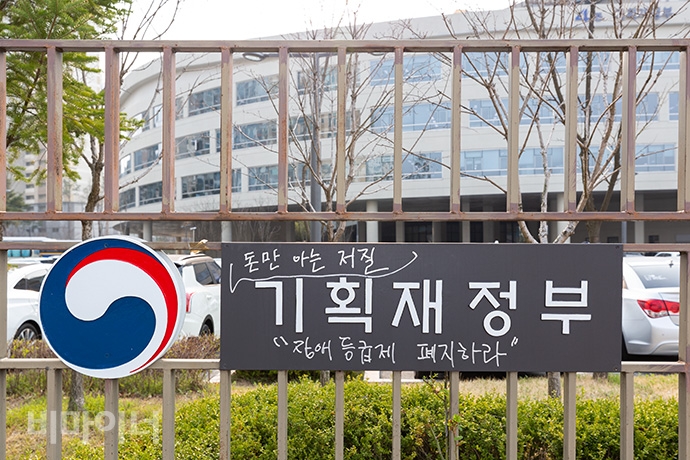 정부세종청사 기획재정부 명판에 '돈만 아는 저질, 장애등급제 폐지'라는 문구를 덧붙여 쓰여 있다. 사진 박승원