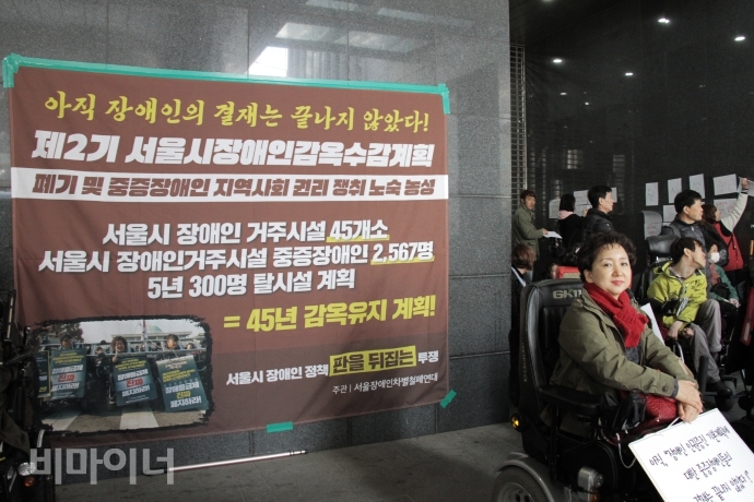 서울시청 후문에 '2기 서울시장애인감옥수감계획 폐지'를 촉구하는 현수막이 걸려있다. 사진 최한별