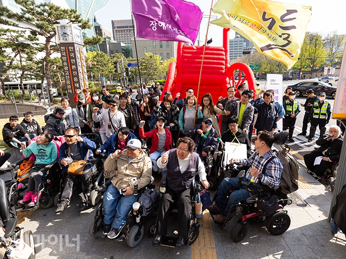 대형휠체어 앞에 모인 420공투단 회원들이 장애인 이동권 보장을 촉구하며 포즈를 취하고 있다. 사진 박승원