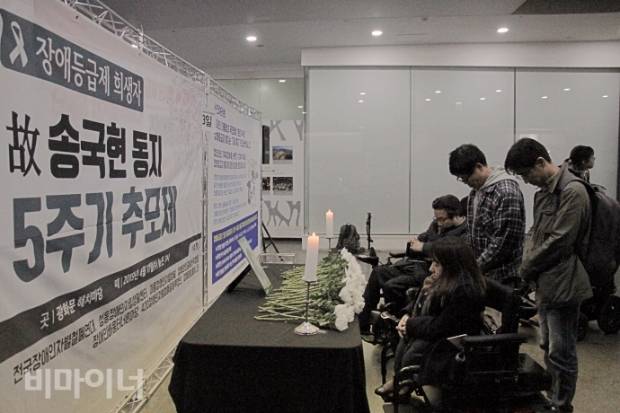 추모제가 끝난 후, 참석자들이 고인의 영정 앞에 흰 국화를 헌화하고 묵념하고 있다. 사진 최한별