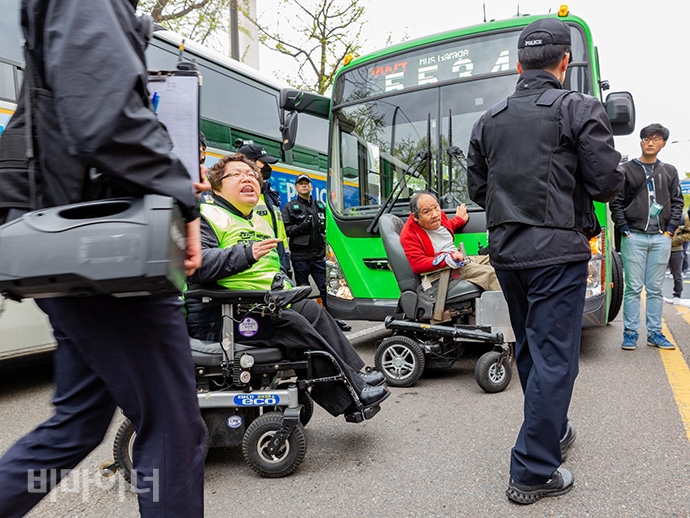 420장애인차별철폐공동투쟁단이 18일 ‘제39회 장애인의 날’ 기념식을 앞둔 오전 10시 “장애인을 차별하는 장애인의 날을 규탄한다”라며 63빌딩 앞 도로를 점거했다. 사진 박승원