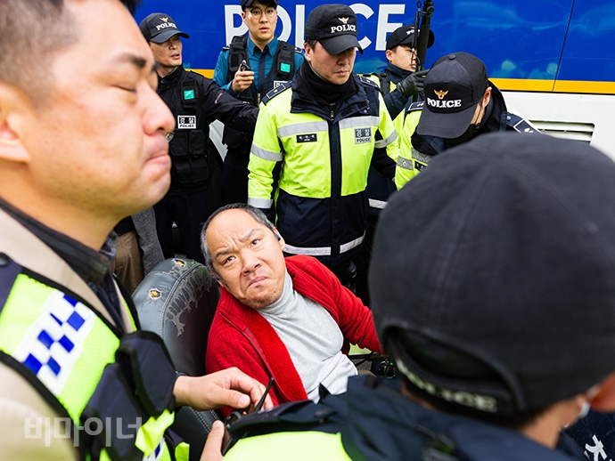 한 장애인 활동가가 “무조건 내쫓기보다 시민의 목소리를 들어주어야 하는 것 아닌가”라고 외치며 경찰과 신경전을 벌이고 있다. 사진 박승원