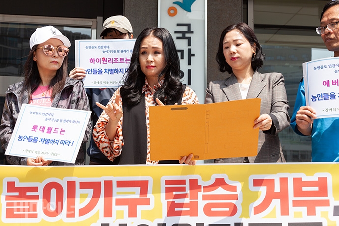 장애의 벽을 허무는 사람들이 14일 오후 2시 인권위 앞에서 기자회견을 열고, “장애의 특성이나 정도를 가리지 않고 놀이기구 이용을 못 하도록 막는 것은 엄연한 차별”이라며 인권위에 차별 진정했다. 유정아 씨가 발언하고 있는 모습. 사진 박승원