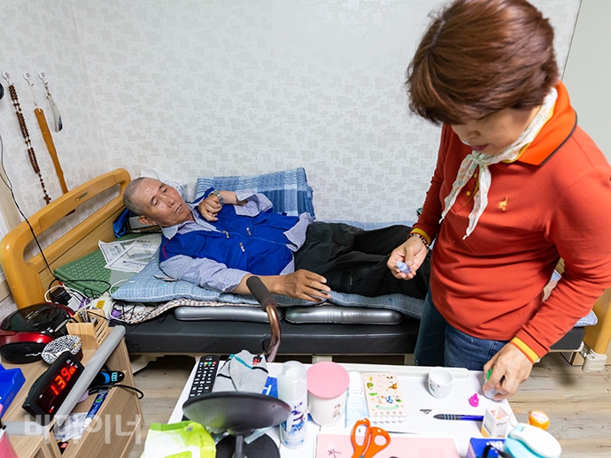 정종삼 씨의 활동지원사가 누워있는 정 씨에게 안약을 넣어주고 있다. 사진 박승원