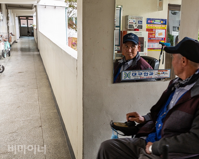 외출에서 돌아오는 길, 정종삼 씨가 아파트 복도에 걸린 거울에 비친 자기 모습을 보고 있다. 사진 박승원