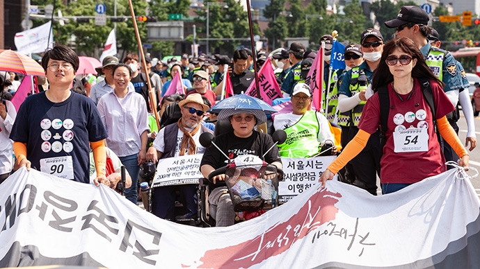 전국장애인차별철폐연대 등 3개 단체가 4일 서울시청 정문 앞에서 ‘서울시 장애인인권증진기본계획 전면수정 환영 및 장애인거주시설폐쇄조례 제정 촉구 기자회견을 열었다. 장애계 활동가들이 기자회견을 마치고 마로니에공원까지 행진하는 모습. 사진 박승원