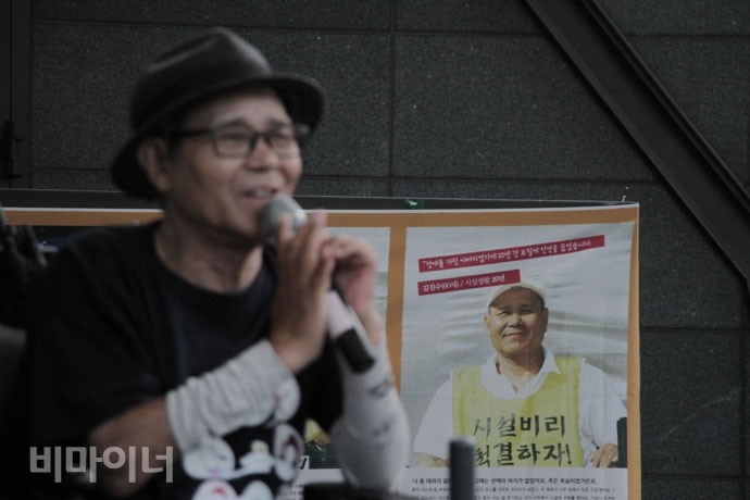 발언하는 김진수 석암비대위 활동가 뒤편에 10년 전 투쟁을 시작했을 당시의 모습이 걸려있다. 사진 강혜민 발언하는 김진수 석암비대위 활동가 뒤편에 10년 전 투쟁을 시작했을 당시의 모습이 걸려있다. 사진 강혜민