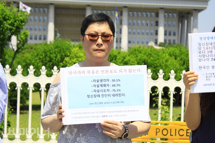 기자회견 참가자가 ‘당사자의 죽음은 언론보도 되지 않는다’는 손팻말을 들고 있다. 사진 허현덕