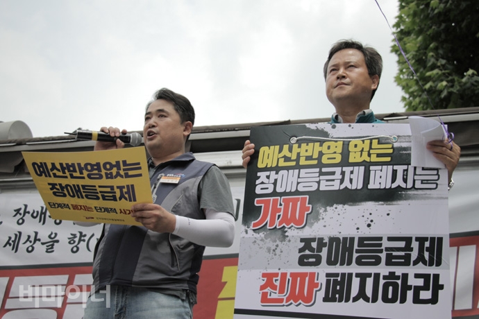 장애등급제 ‘진짜’ 폐지를 위한 투쟁 선포식에서 연대 발언을 하고 있는 권정오 전교조 위원장과 손팻말을 들고 있는 공민규 전국공공운수노동조합 구긴연금지부 위원장의 모습. 사진 강혜민 장애등급제 ‘진짜’ 폐지를 위한 투쟁 선포식에서 연대 발언을 하고 있는 권정오 전교조 위원장과 손팻말을 들고 있는 공민규 전국공공운수노동조합 국민연금지부 위원장의 모습. 사진 강혜민