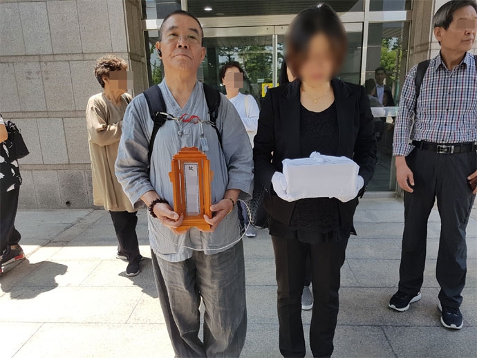 위패를 든 자원봉사자분과 동생의 유골함을 들고 오열하는 누나