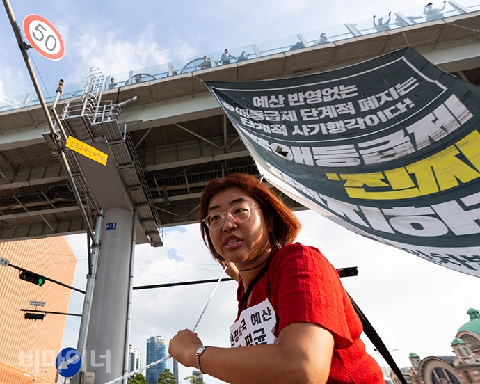 한 활동가가 바람에 휘날리는 대형 현수막을 붙잡고 있다. 사진 박승원