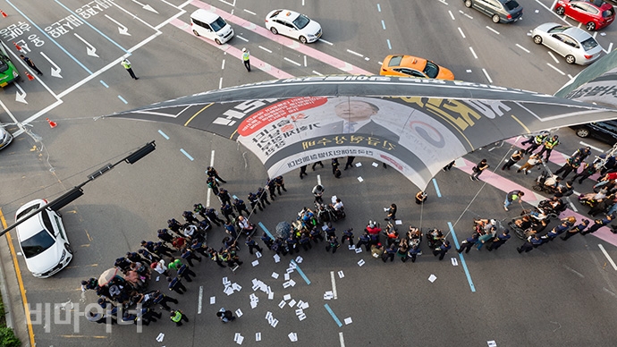 서울역 앞 교차로를 점거한 장애인 활동가들. 대형 현수막과 바닥에 떨어진 선전물들이 보인다. 사진 박승원