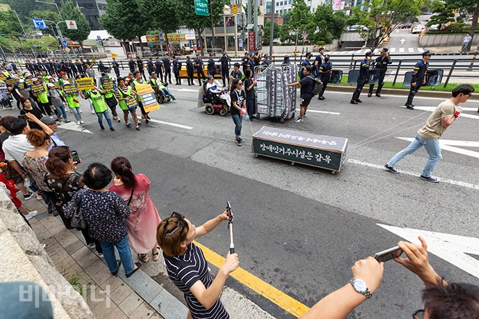 결의대회를 마친 전장연은 오후 4시 더불어민주당 당사가 있는 여의도 방향으로 행진을 했다. 가는 도중 충정로 사거리 육교에서 장애계 요구안이 담긴 대형 현수막을 내 거는 과정에서 경찰과 마찰을 빚기도 했다. 사진 박승원